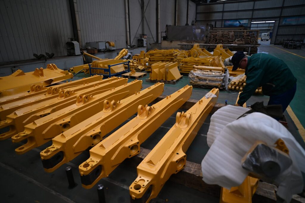 Rows of motor grader frames in workshop